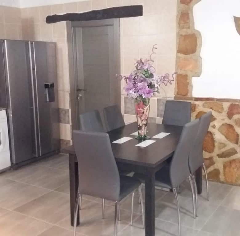 Charming interior of a cave house in Fontanar, Jaen, featuring a modern dining area with a table and.