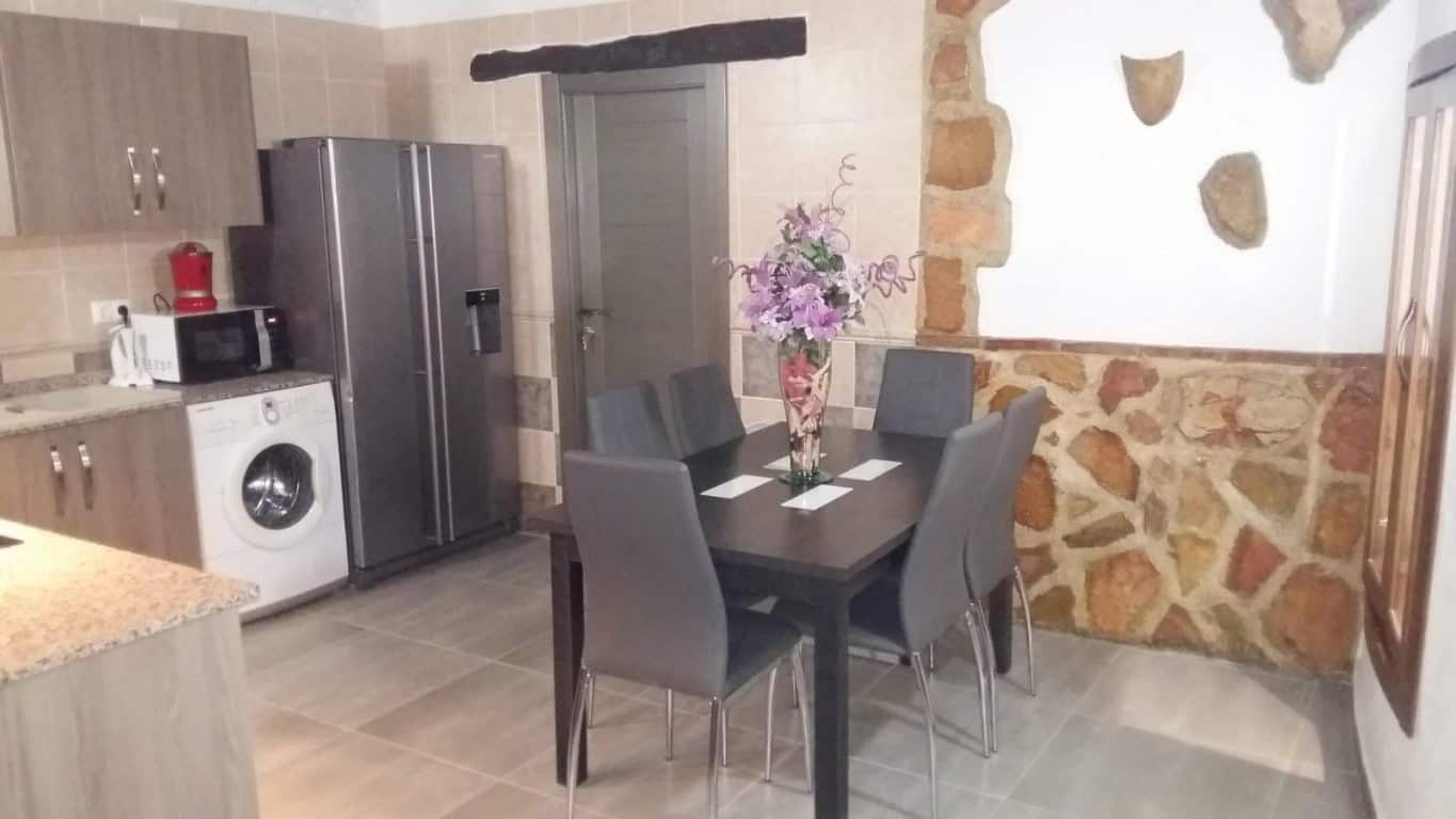 Charming interior of a cave house in Fontanar, Jaen, featuring a modern dining area with a table and.