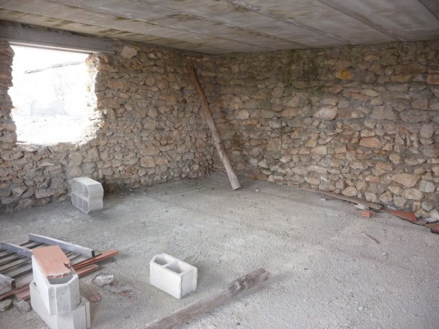 Ancient stone ruin in Cullar, Granada, under renovation, with exposed stone walls and construction m.