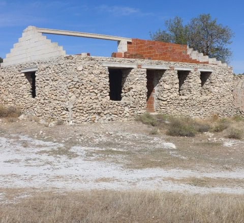 Abandoned stone ruin in Cullar, Granada, showcasing historic architecture and scenic rural surroundi.