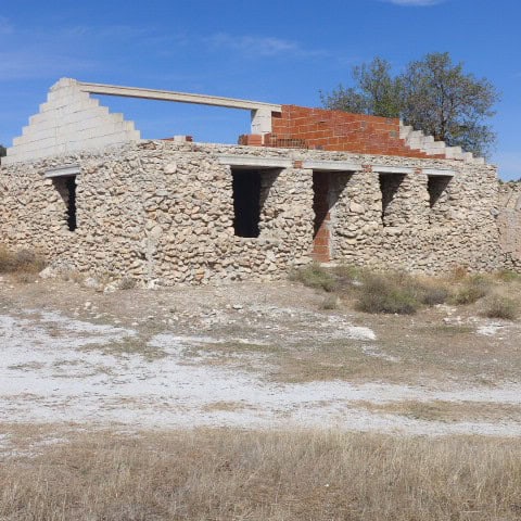 Abandoned stone ruin in Cullar, Granada, showcasing historic architecture and scenic rural surroundi.