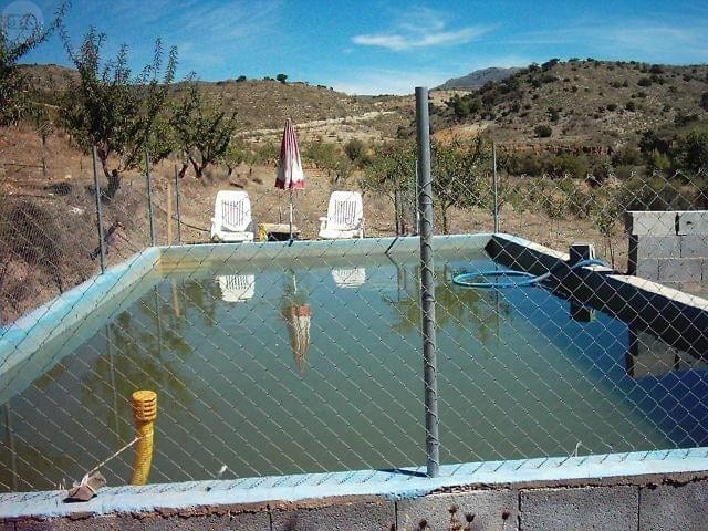 Farm property with a swimming pool in Tijola, Almeria, surrounded by scenic hills and rural landscap.