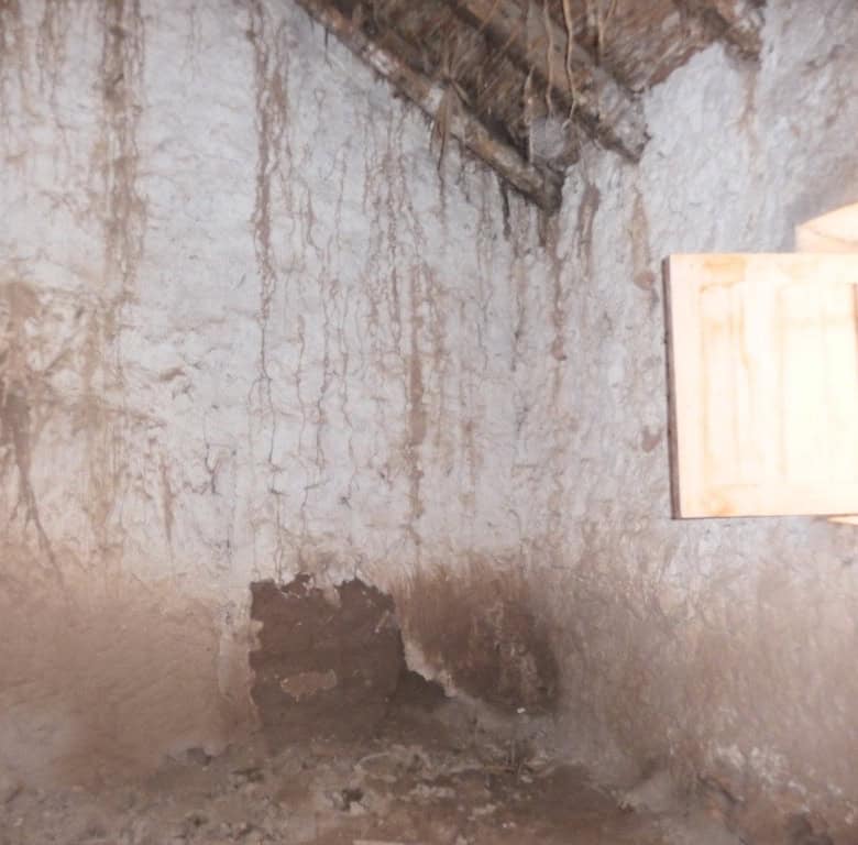 Cave house interior in Freila, Granada with rustic walls and a small window.