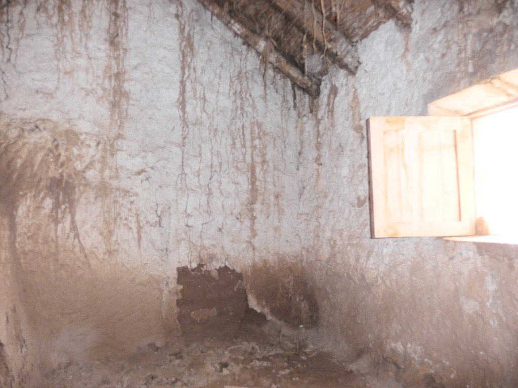 Cave house interior in Freila, Granada with rustic walls and a small window.