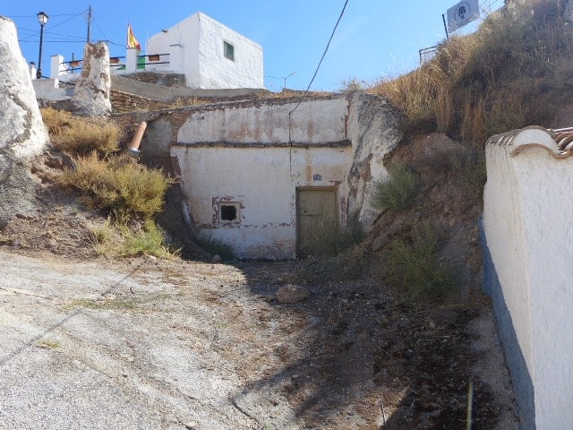 Cave house in Freila, Granada with white exterior walls and hillside location.