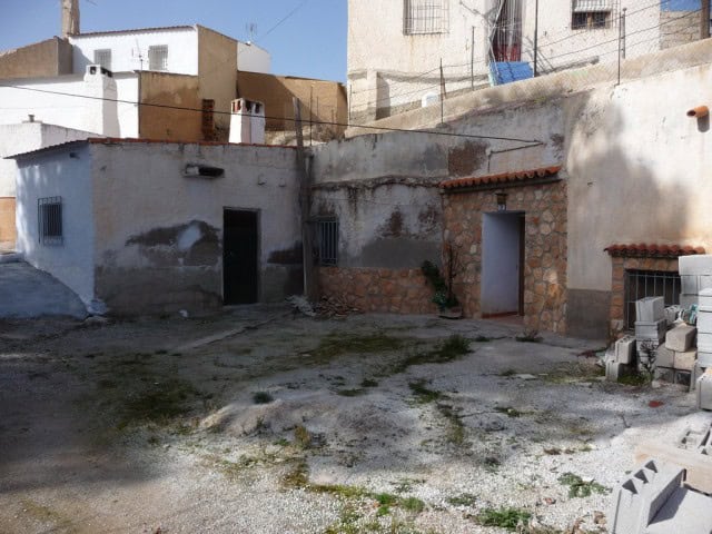 Cave house in Freila, Granada, with rustic stone walls and simple entrance.