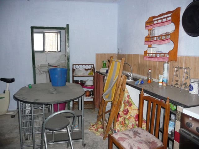 Cozy cave house interior in Freila, Granada, featuring simple furnishings and rustic decor.