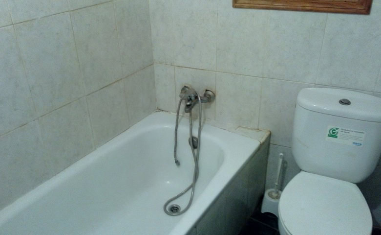 Charming village property bathroom in Zujar, Granada with bathtub and basic fixtures.