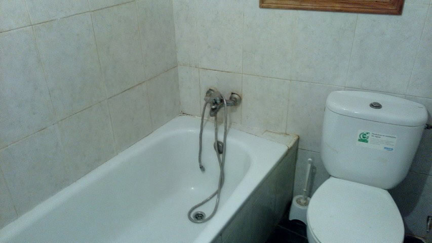 Charming village property bathroom in Zujar, Granada with bathtub and basic fixtures.