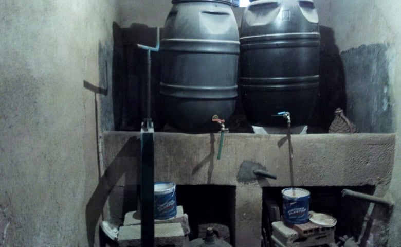 Water storage tanks and plumbing setup in a rural village property in Zujar, Granada.