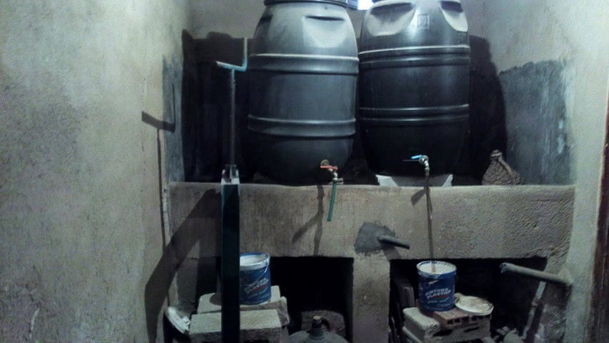Water storage tanks and plumbing setup in a rural village property in Zujar, Granada.