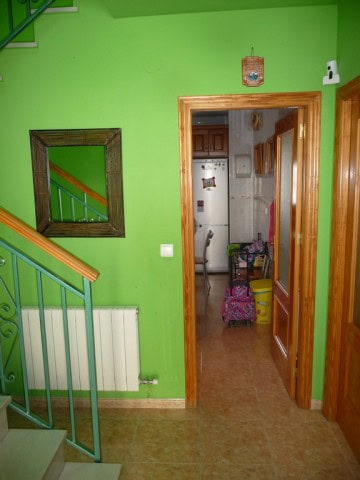 Charming village home entrance in Zujar, Granada with vibrant green walls and wooden door frame.