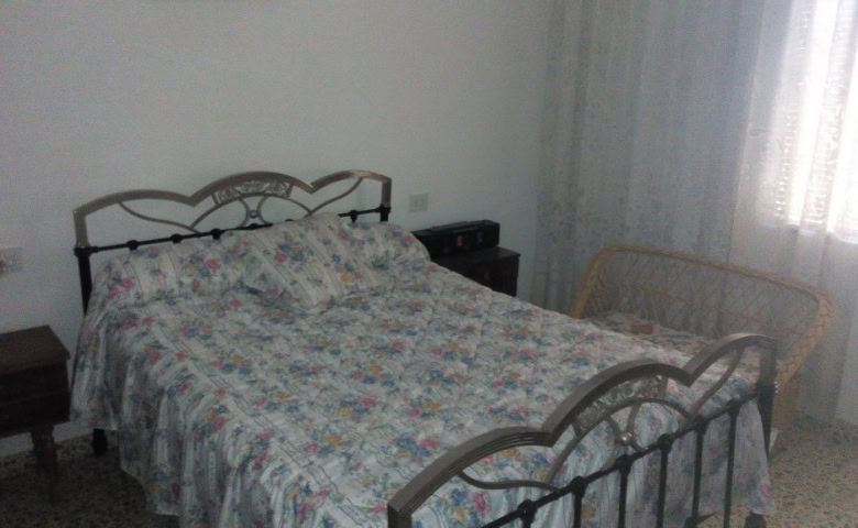 Charming village house in Zujar, Granada, featuring a cozy bedroom with vintage metal bed frame and.