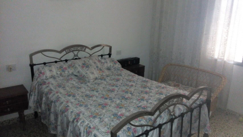 Charming village house in Zujar, Granada, featuring a cozy bedroom with vintage metal bed frame and.