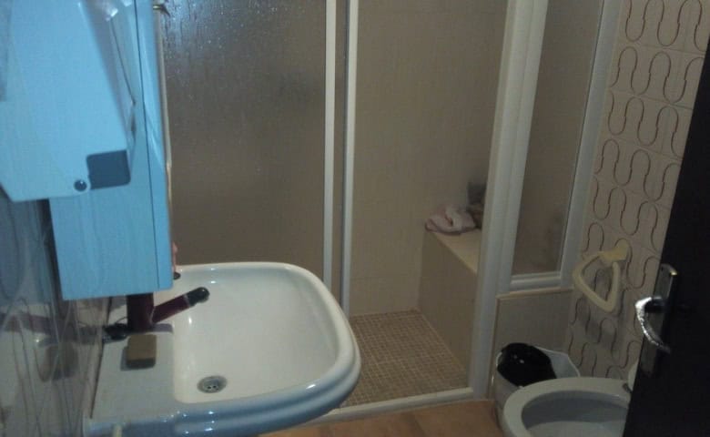 Interior view of a small village bathroom with shower, sink, and modern fixtures in Zujar, Granada.