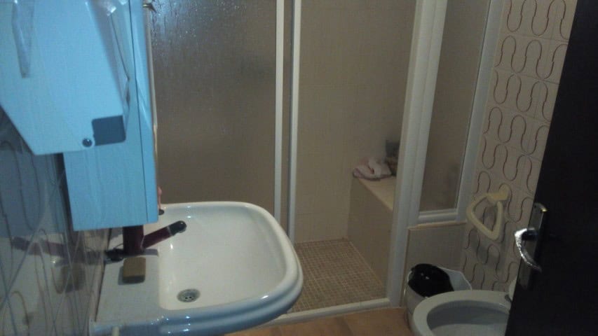Interior view of a small village bathroom with shower, sink, and modern fixtures in Zujar, Granada.