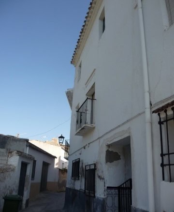 Village property in Zujar, Granada with traditional white facade and small balcony. Perfect for a qu.