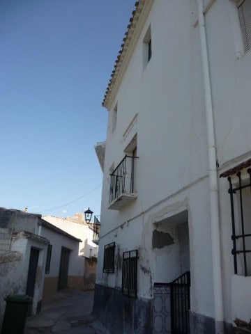 Village property in Zujar, Granada with traditional white facade and small balcony. Perfect for a qu.