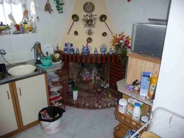 Cozy kitchen with fireplace and decorative wall accents in a traditional village property.