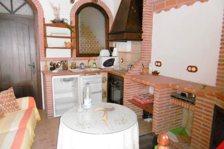 Charming kitchen in a village property in Hinojares, Jaen, featuring rustic brick walls, a small din.