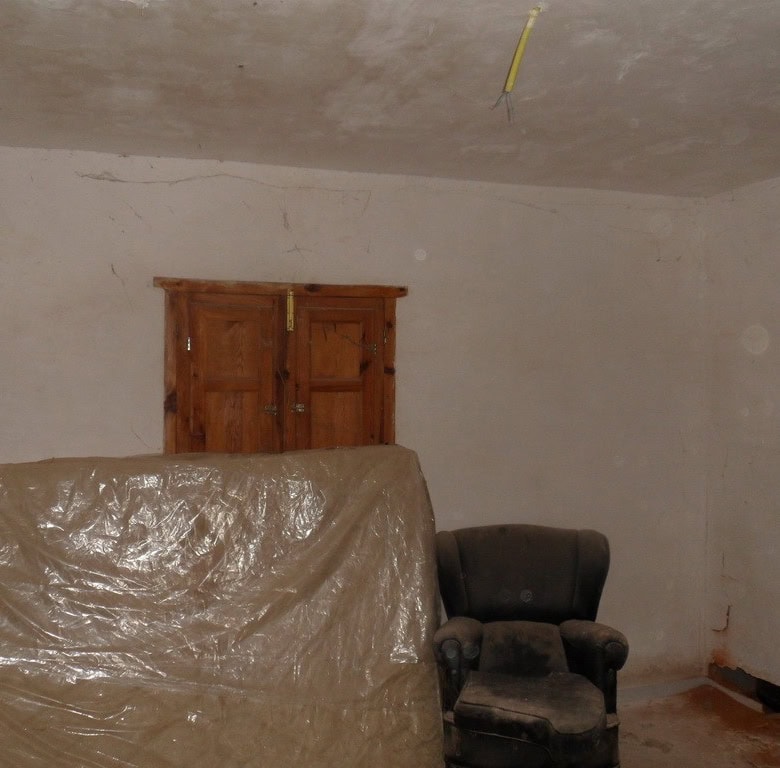 Charming interior of a village property in Freila, Granada, showing a rustic room with wooden door a.
