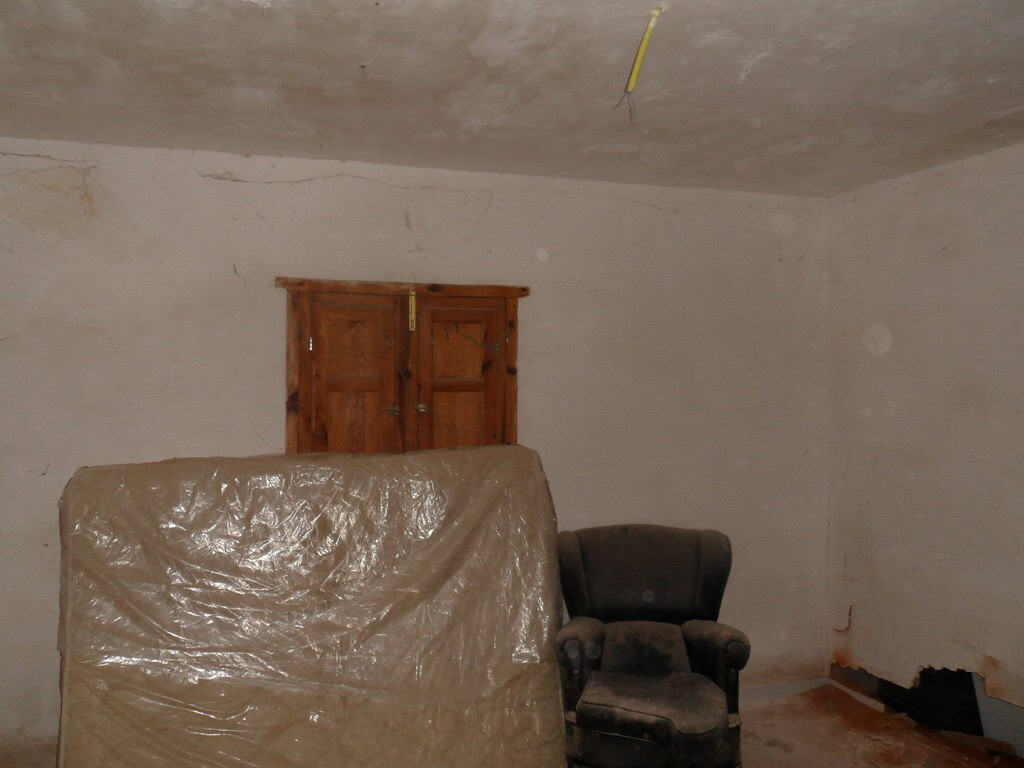 Charming interior of a village property in Freila, Granada, showing a rustic room with wooden door a.