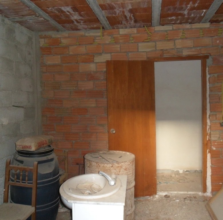 Village property interior with unfinished walls and basic fixtures in Freila, Granada.