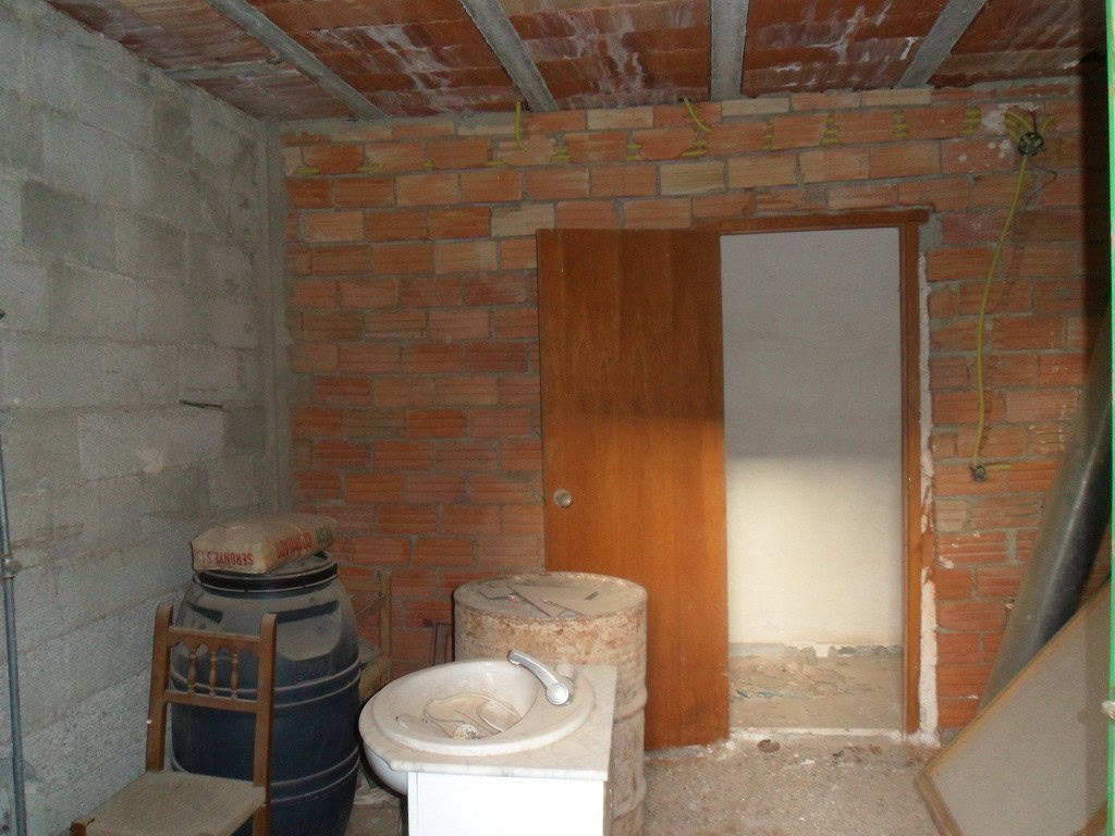 Village property interior with unfinished walls and basic fixtures in Freila, Granada.