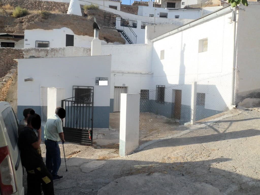 Charming cave house in Freila, Granada, with whitewashed walls and scenic surroundings.