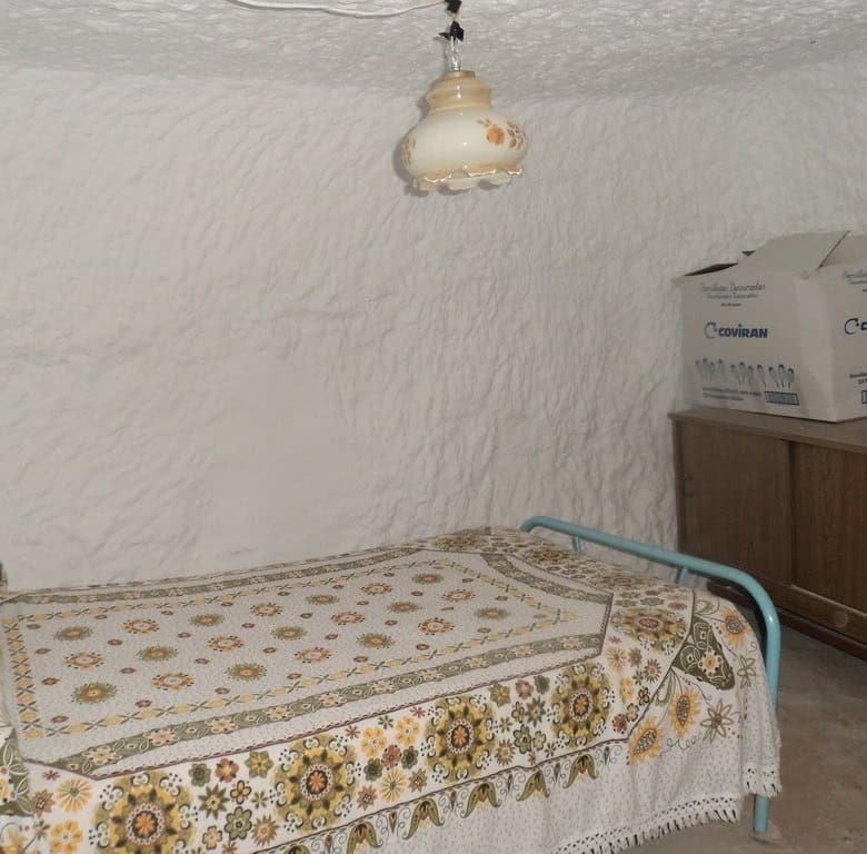 Interior of a traditional cave house in Freila, Granada with rustic furniture and vintage decor.