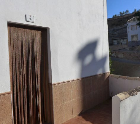 Town house entrance with wooden door and house number 4 in Fontanar, Jaen.