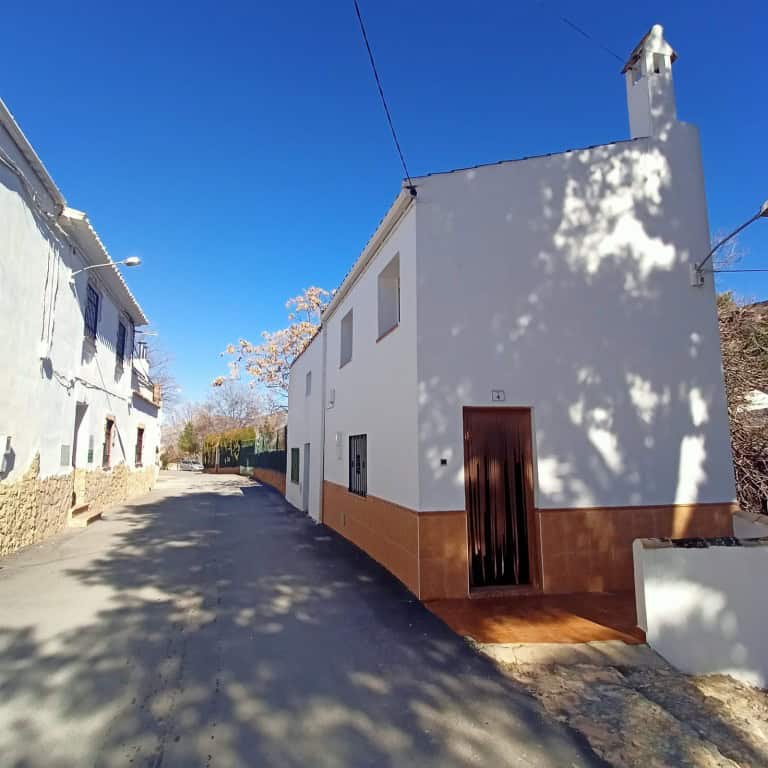 Charming white town house in Fontanar, Jaen, with traditional architecture and scenic street views.
