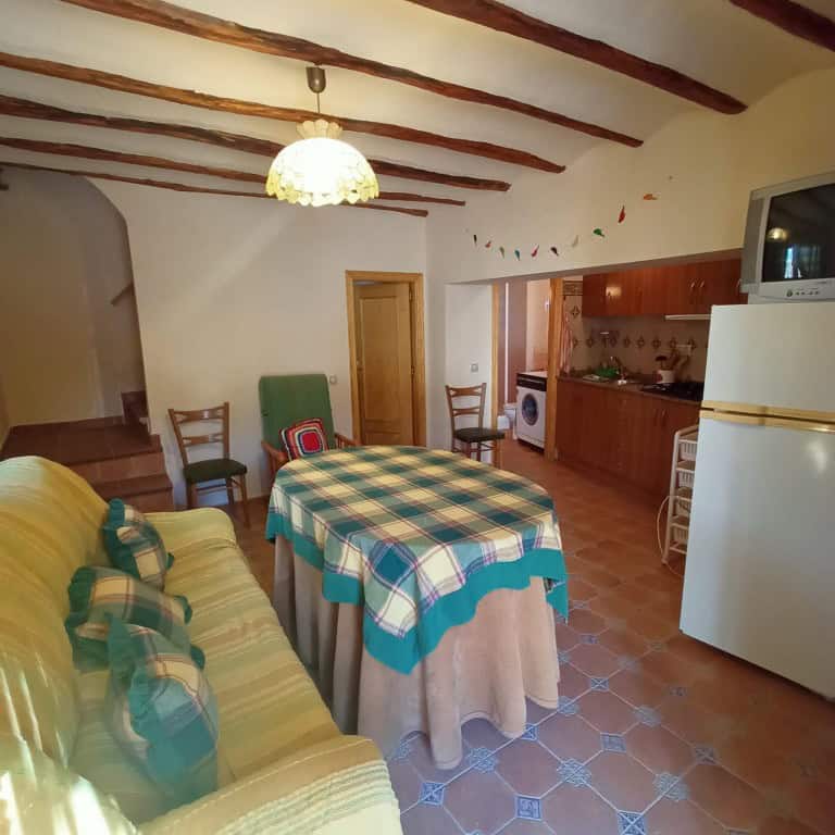 Cozy interior of a town house in Fontanar, Jaen, featuring a living area with a sofa, dining table,.