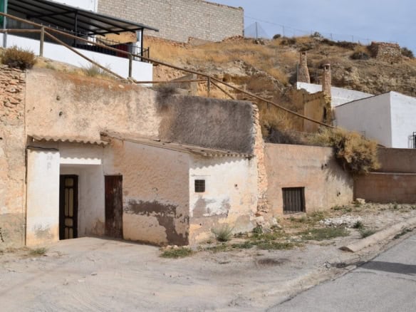 Cave house in Cuevas del Campo, Granada, with rustic exterior and hillside setting.