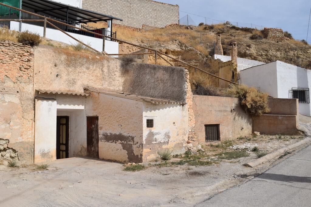 Cave house in Cuevas del Campo, Granada, with rustic exterior and hillside setting.