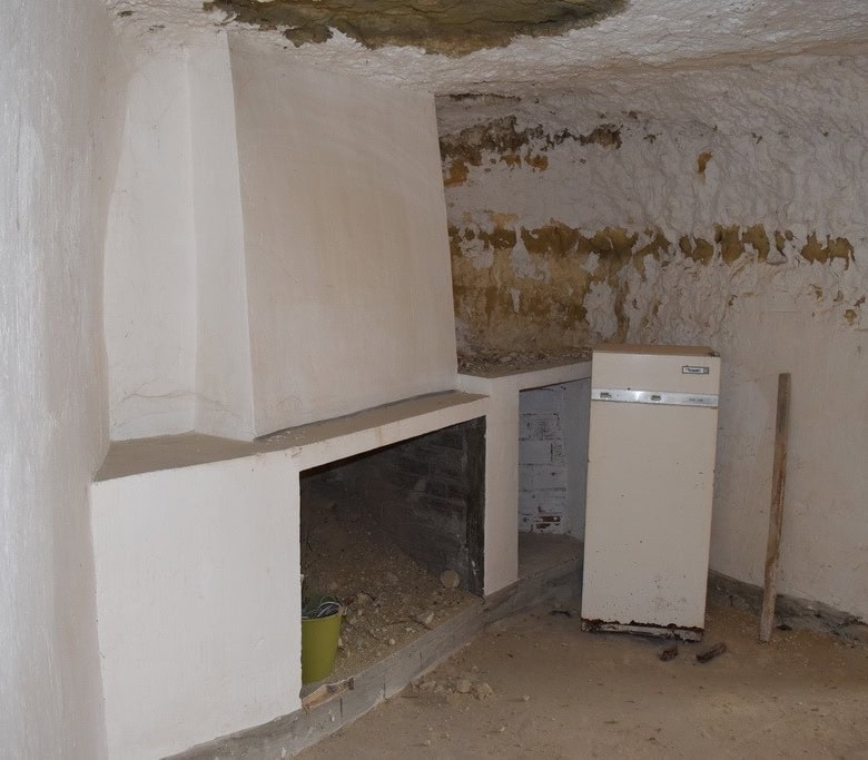 Charming cave house interior in Cuevas del Campo, Granada, showcasing rustic stone walls and traditi.