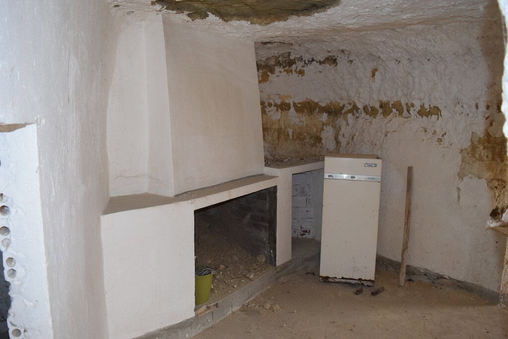 Charming cave house interior in Cuevas del Campo, Granada, showcasing rustic stone walls and traditi.