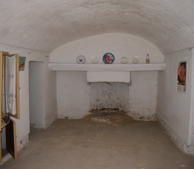 Cave house interior with whitewashed walls and rustic decor in Cuevas del Campo, Granada.
