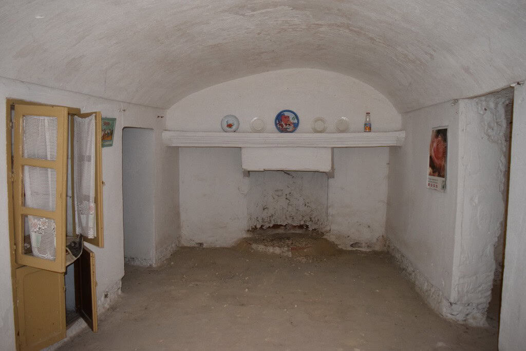 Cave house interior with whitewashed walls and rustic decor in Cuevas del Campo, Granada.