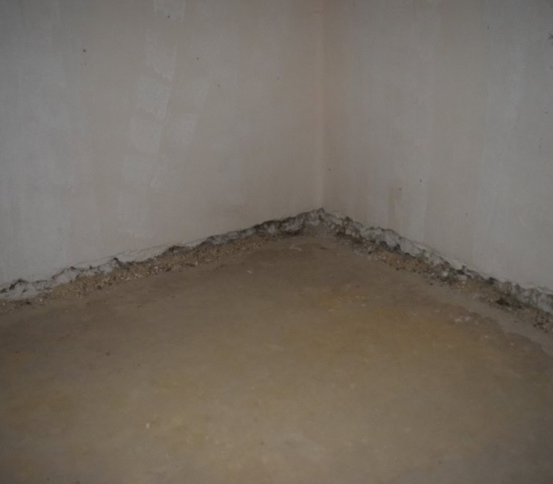 Interior of a cave house in Cuevas del Campo, Granada, showing unfinished walls and floor.