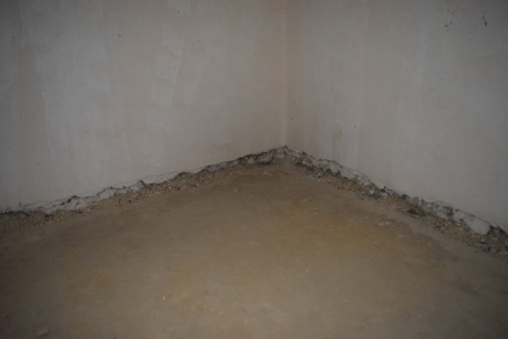 Interior of a cave house in Cuevas del Campo, Granada, showing unfinished walls and floor.