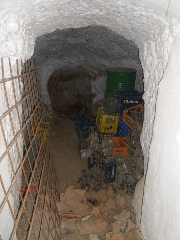 Interior of a cave house with storage crates and barrels in Cuevas del Campo, Granada.