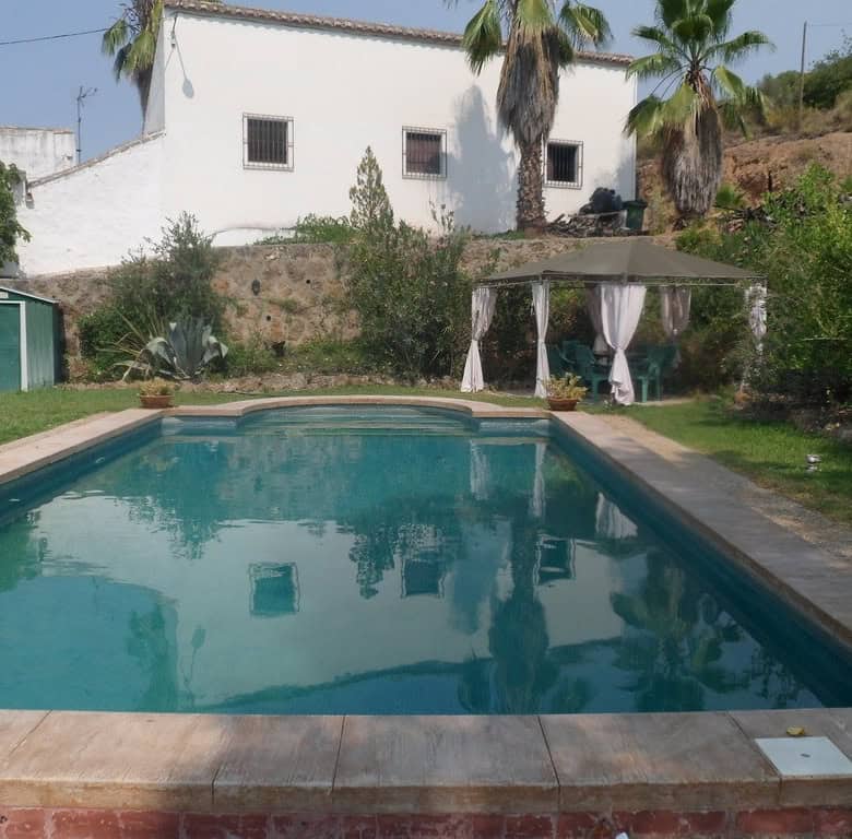 Pool in Loja, Granada with garden and outdoor seating area.