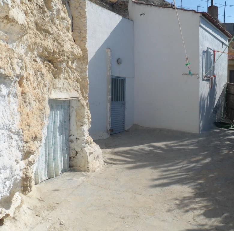 Cave house exterior in Cuevas del Campo, Granada, showcasing traditional stone walls and whitewashed.