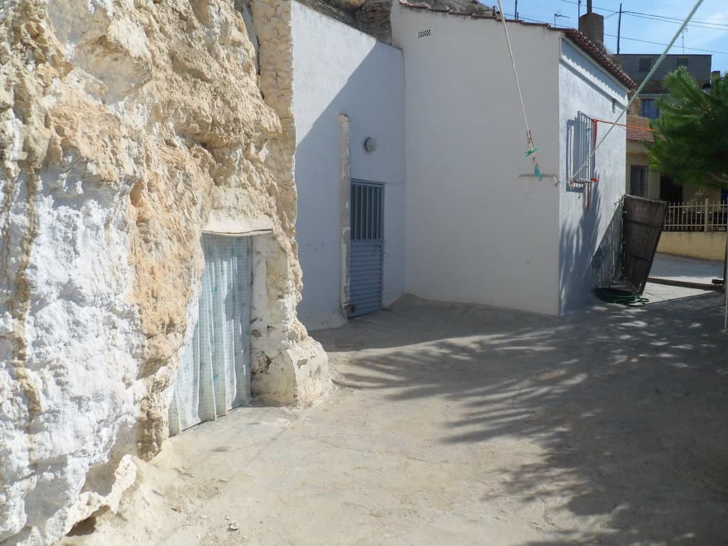 Cave house exterior in Cuevas del Campo, Granada, showcasing traditional stone walls and whitewashed.