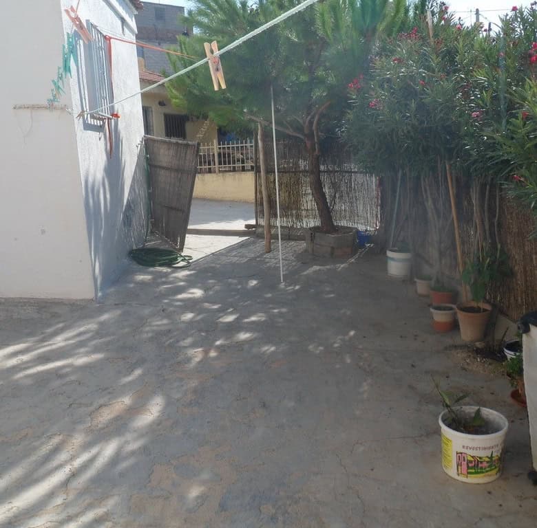 Cave house exterior in Cuevas del Campo, Granada with outdoor space and potted plants.