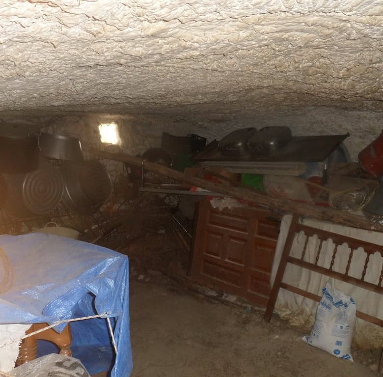 Cave house interior with rustic furniture and storage in Cuevas del Campo, Granada. Unique undergrou.