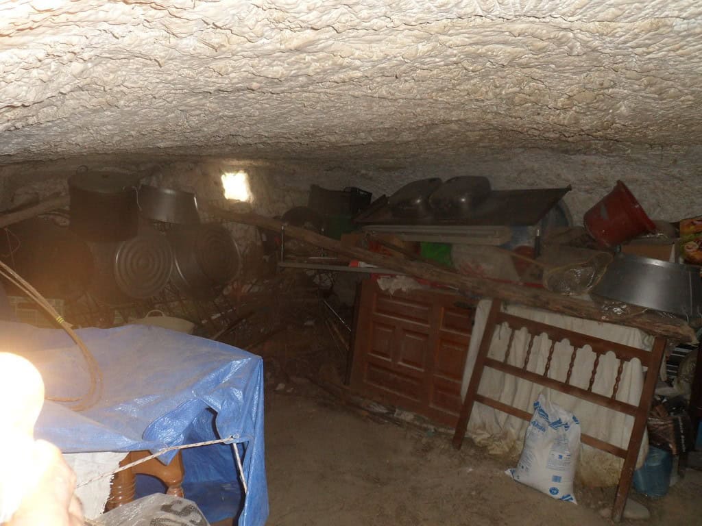 Cave house interior with rustic furniture and storage in Cuevas del Campo, Granada. Unique undergrou.