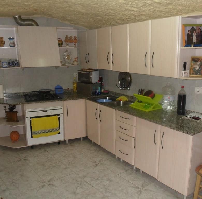 Charming cave house kitchen in Cuevas del Campo, Granada, featuring modern appliances and rustic dec.