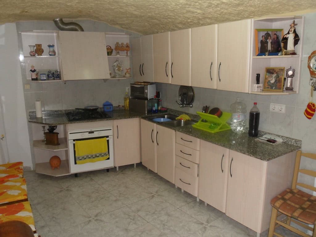 Charming cave house kitchen in Cuevas del Campo, Granada, featuring modern appliances and rustic dec.
